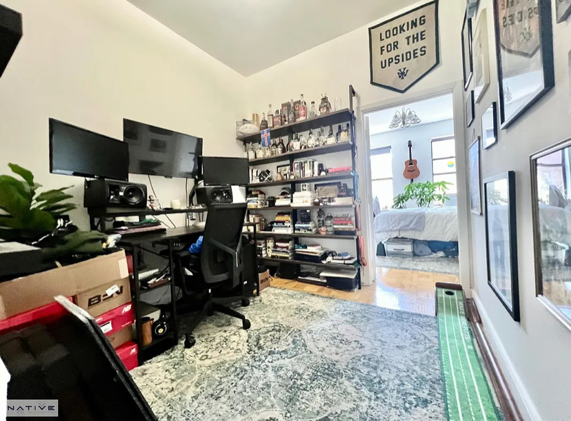 Espacio de trabajo con estanterías y dos monitores.