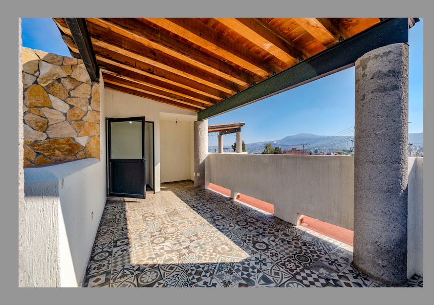 Terraza amplia con techo de madera y piso decorativo.