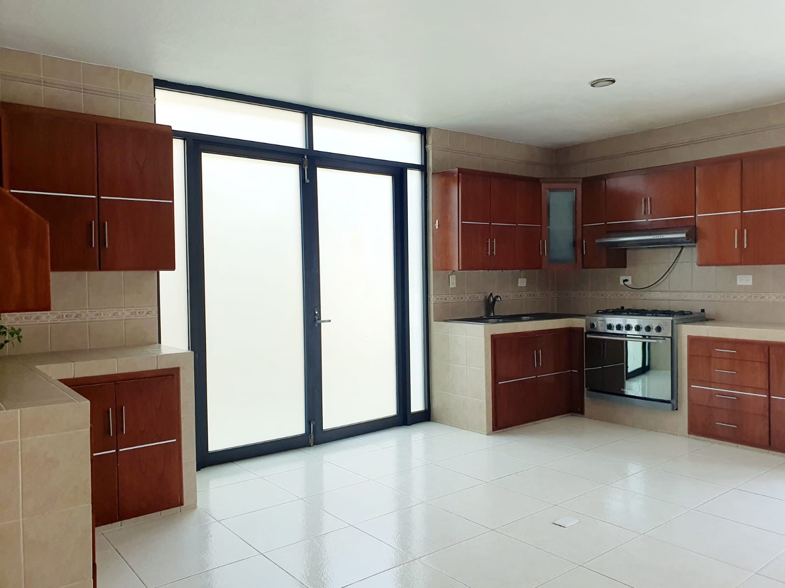 Cocina integral con acabados de madera y buena iluminación.