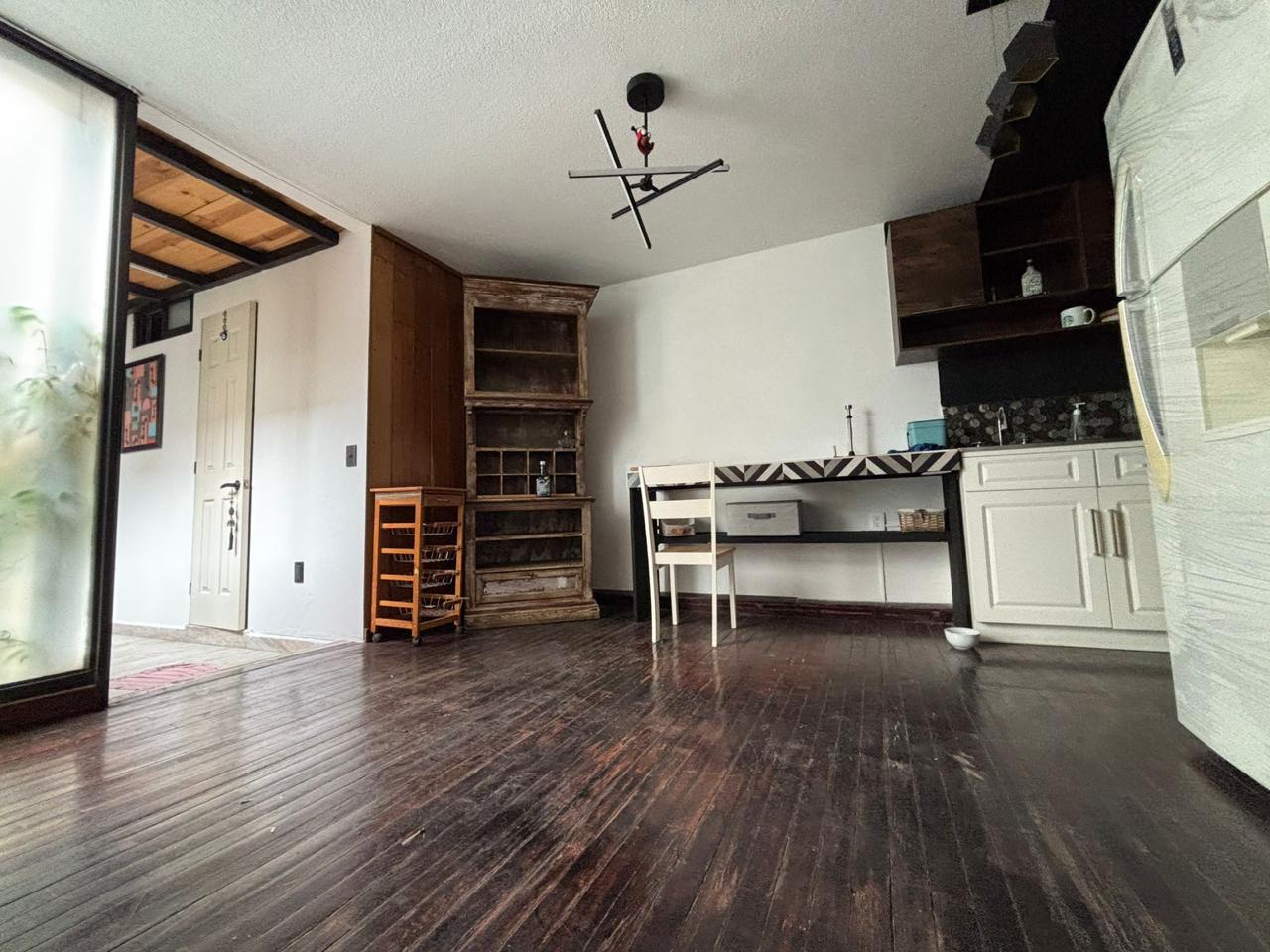 Cocina con acabados de madera y moderna iluminación, integra área de comedor.