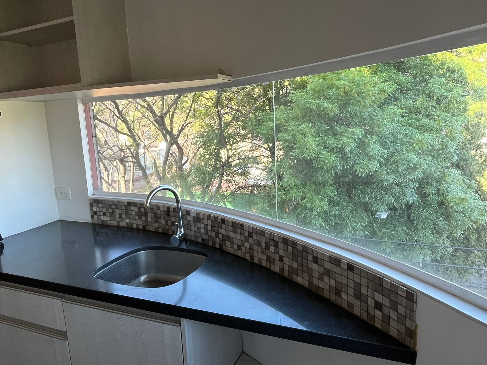 Cocina integral con barra de granito y ventana con vista al exterior.
