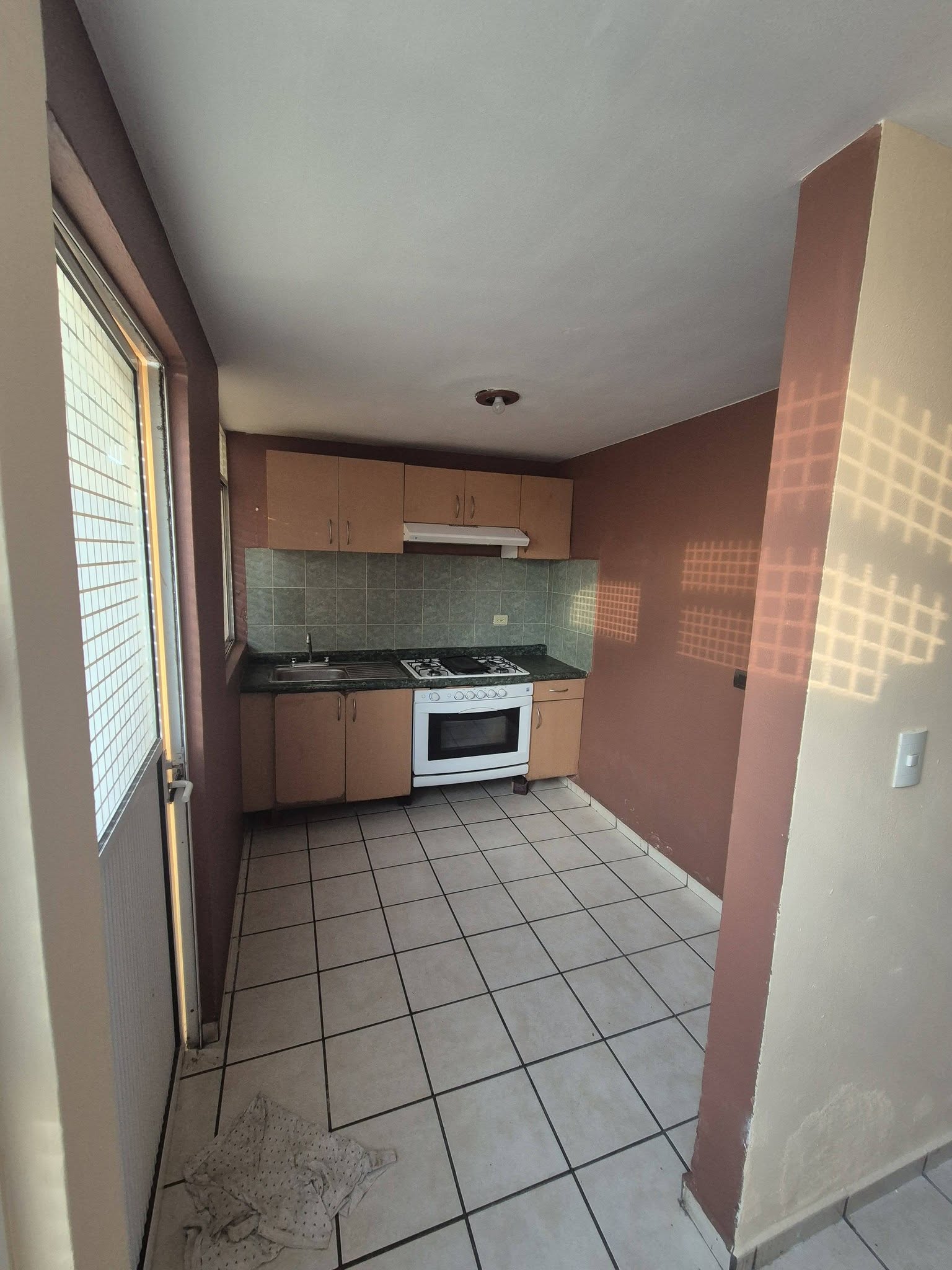 Cocina con estufa y gabinetes, espacio funcional para cocinar.