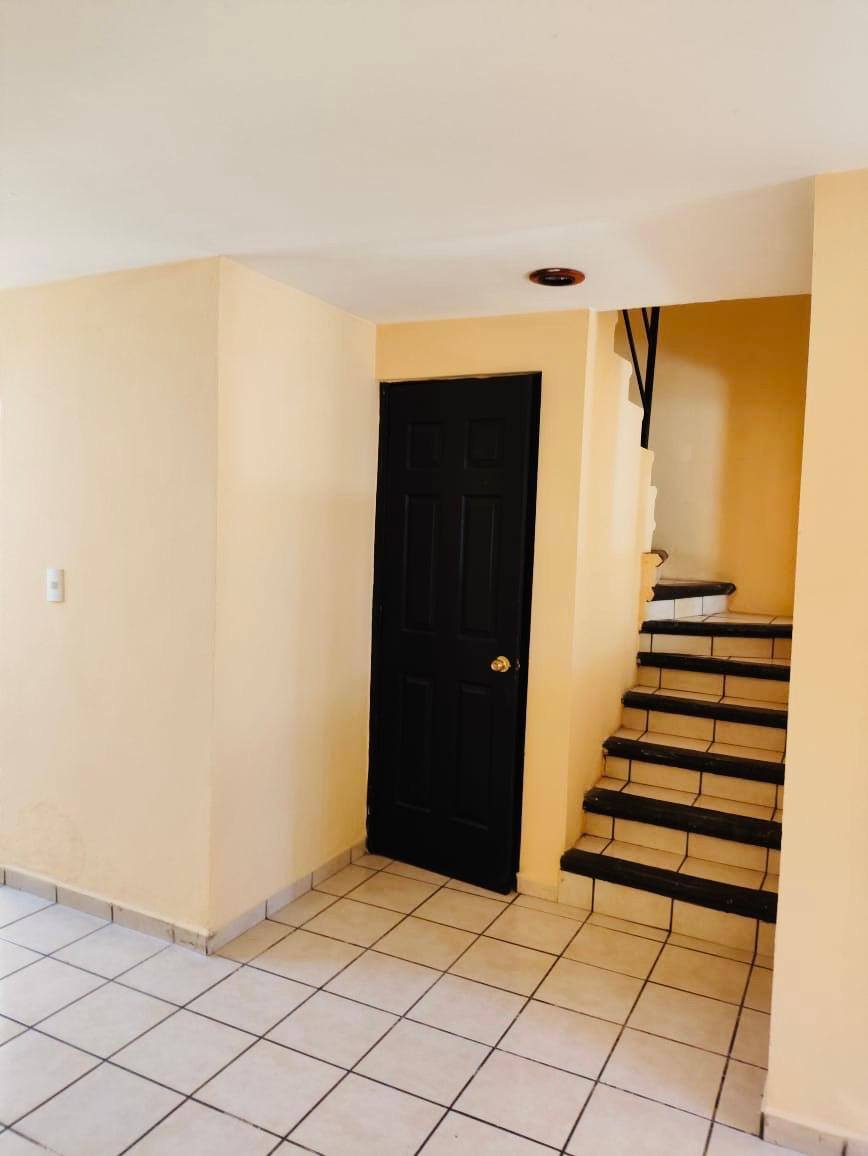 Entrada y escaleras con espacio para almacenamiento.