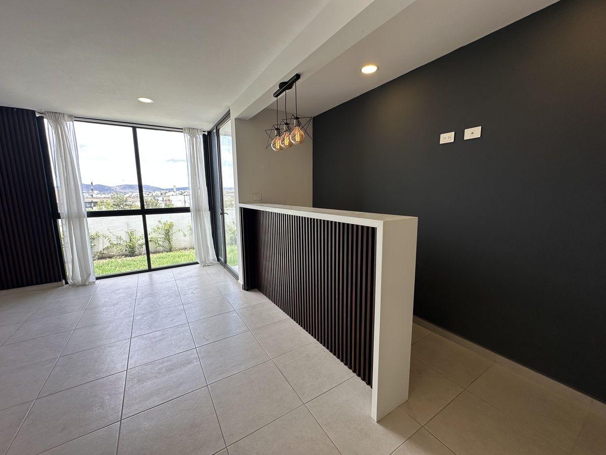 Espaciosa sala-comedor con ventanales de piso a techo y acceso al jardín.