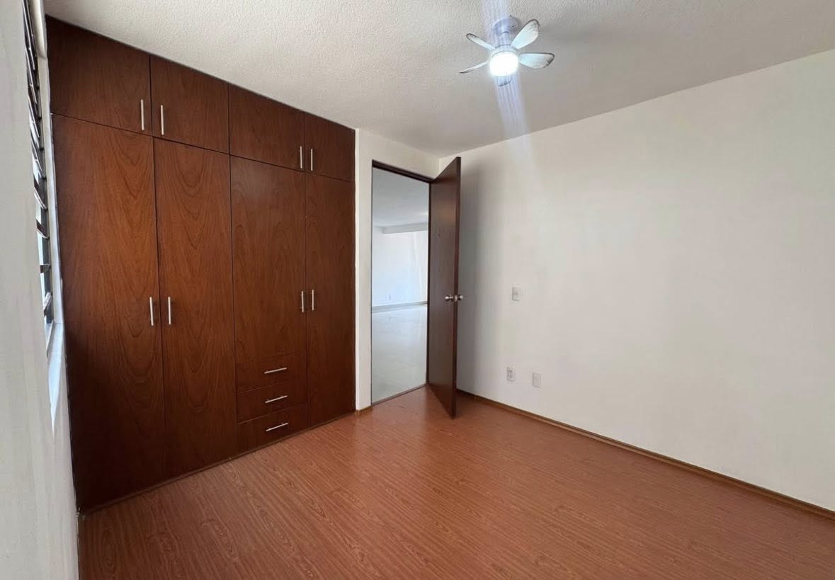 Recámara con closet amplio y piso laminado.