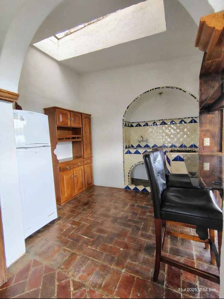 Cocina integrada con barra desayunador y azulejos decorativos, iluminada por un tragaluz.