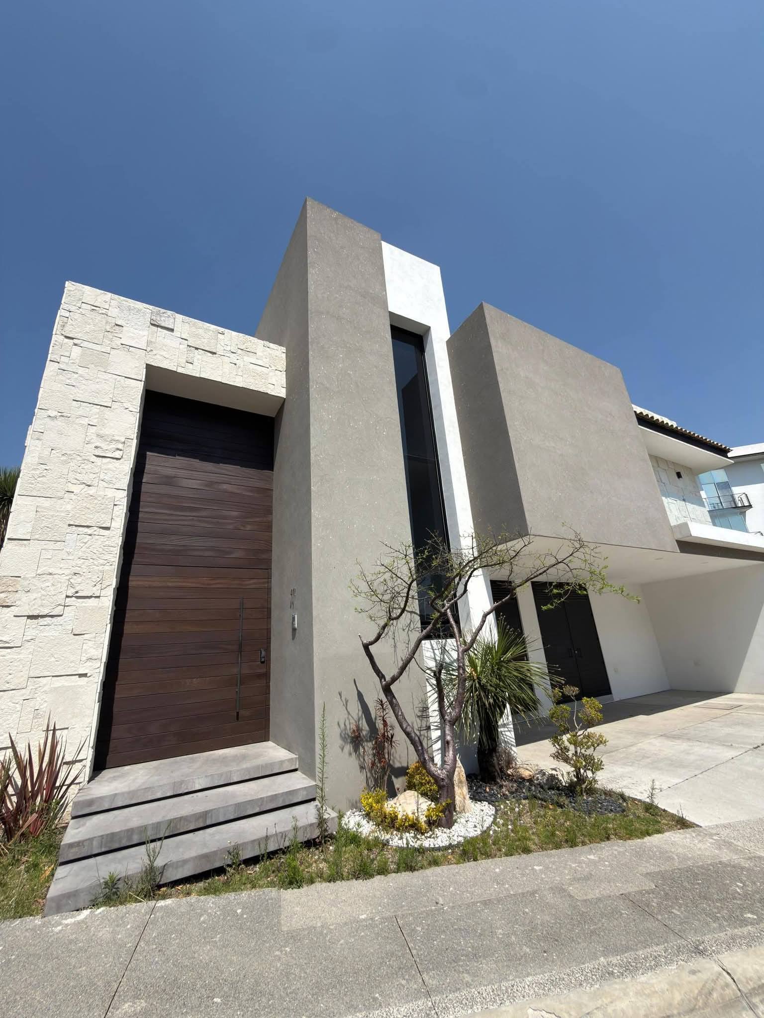 Fachada moderna con diseño arquitectónico contemporáneo, incluye jardín frontal.