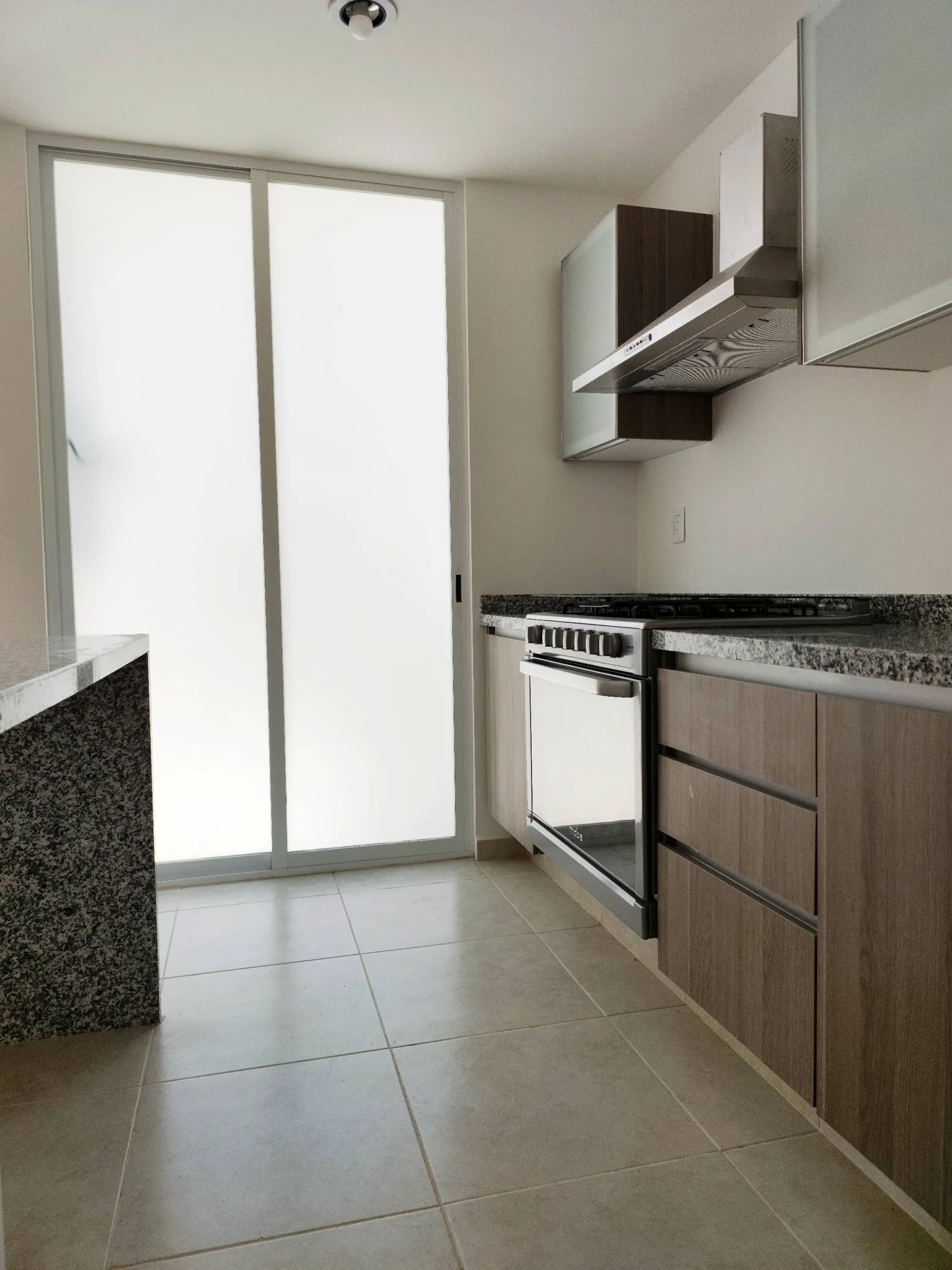Cocina integral moderna con acabados de granito y gabinetes de madera.