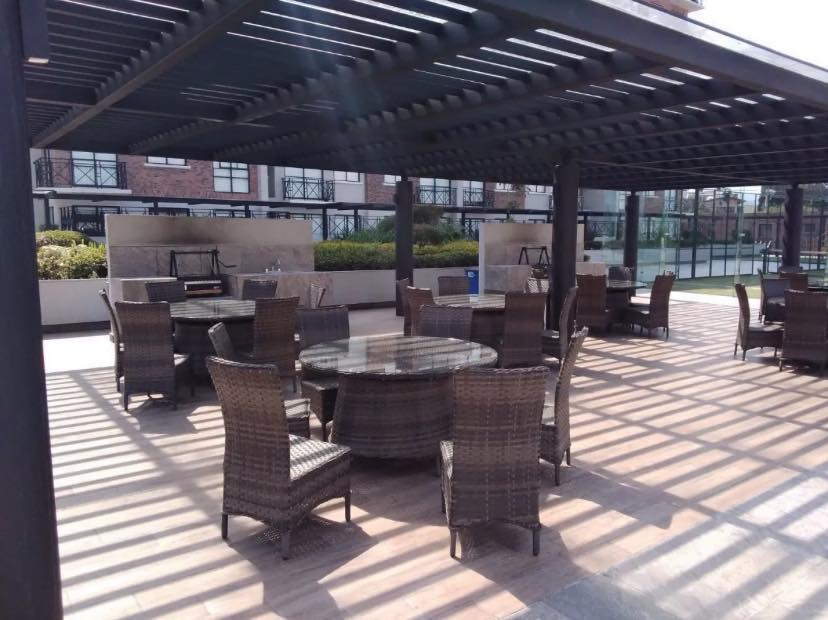 Terraza con mobiliario para convivencias al aire libre bajo una pérgola.