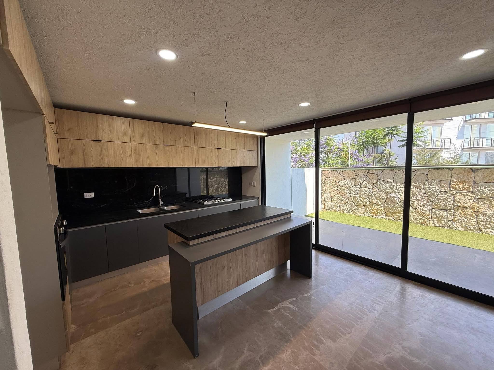 Cocina integral moderna con isla y acabados en madera.