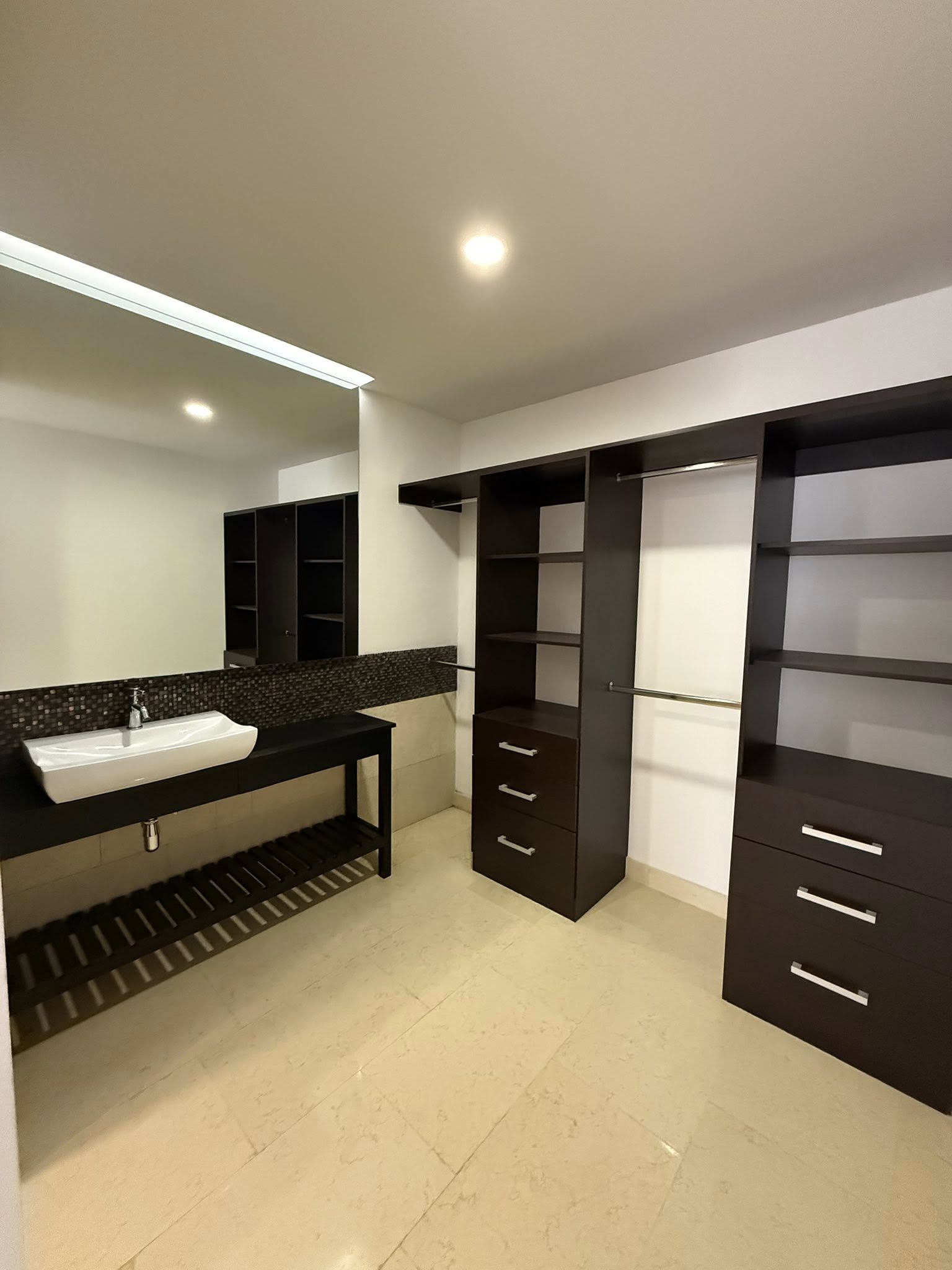 Baño con vestidor y acabados modernos.