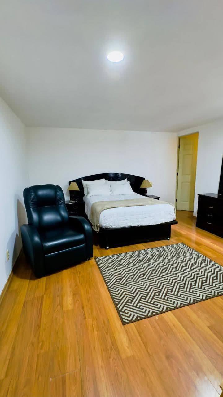 Recámara amplia con cama cómoda y sillón reclinable.