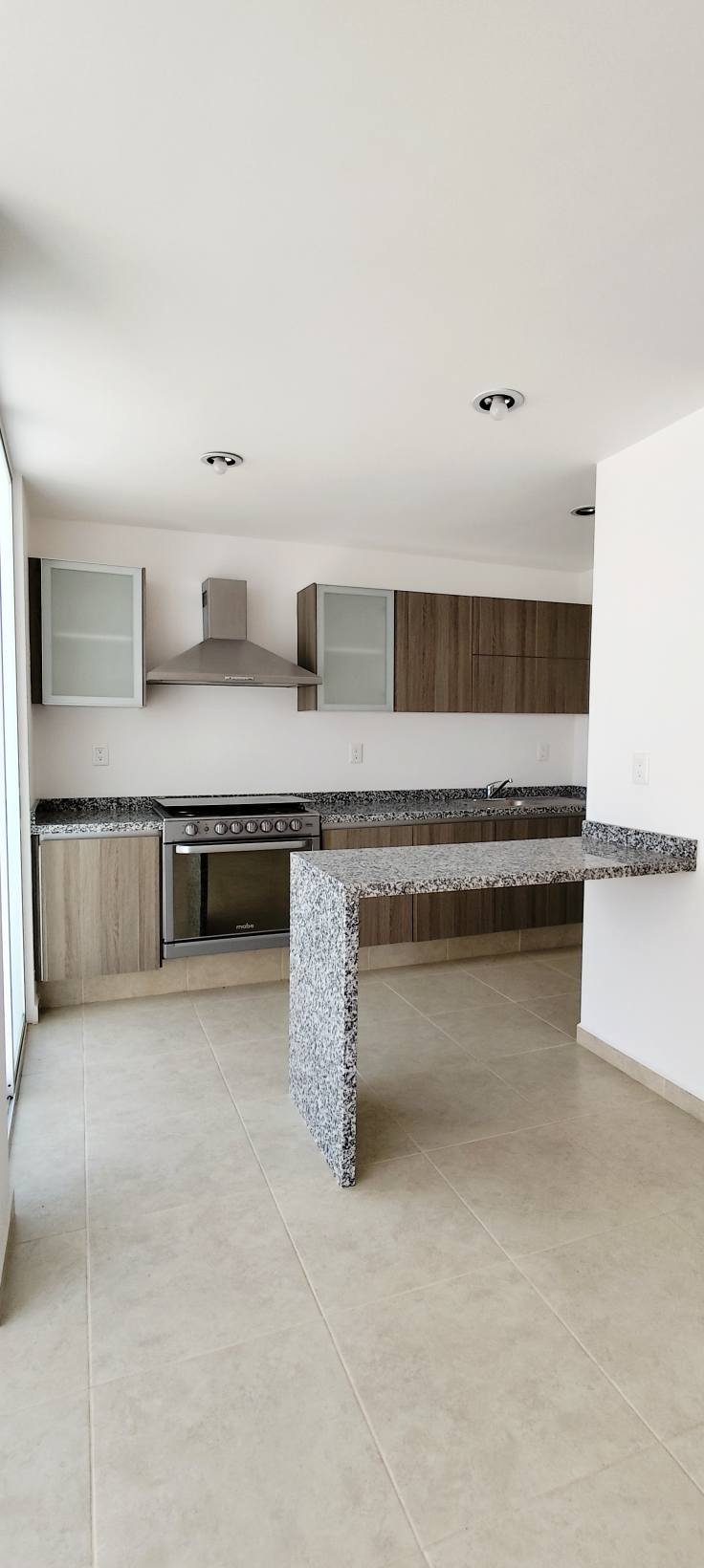 Cocina con barra de granito, ideal para desayunos.