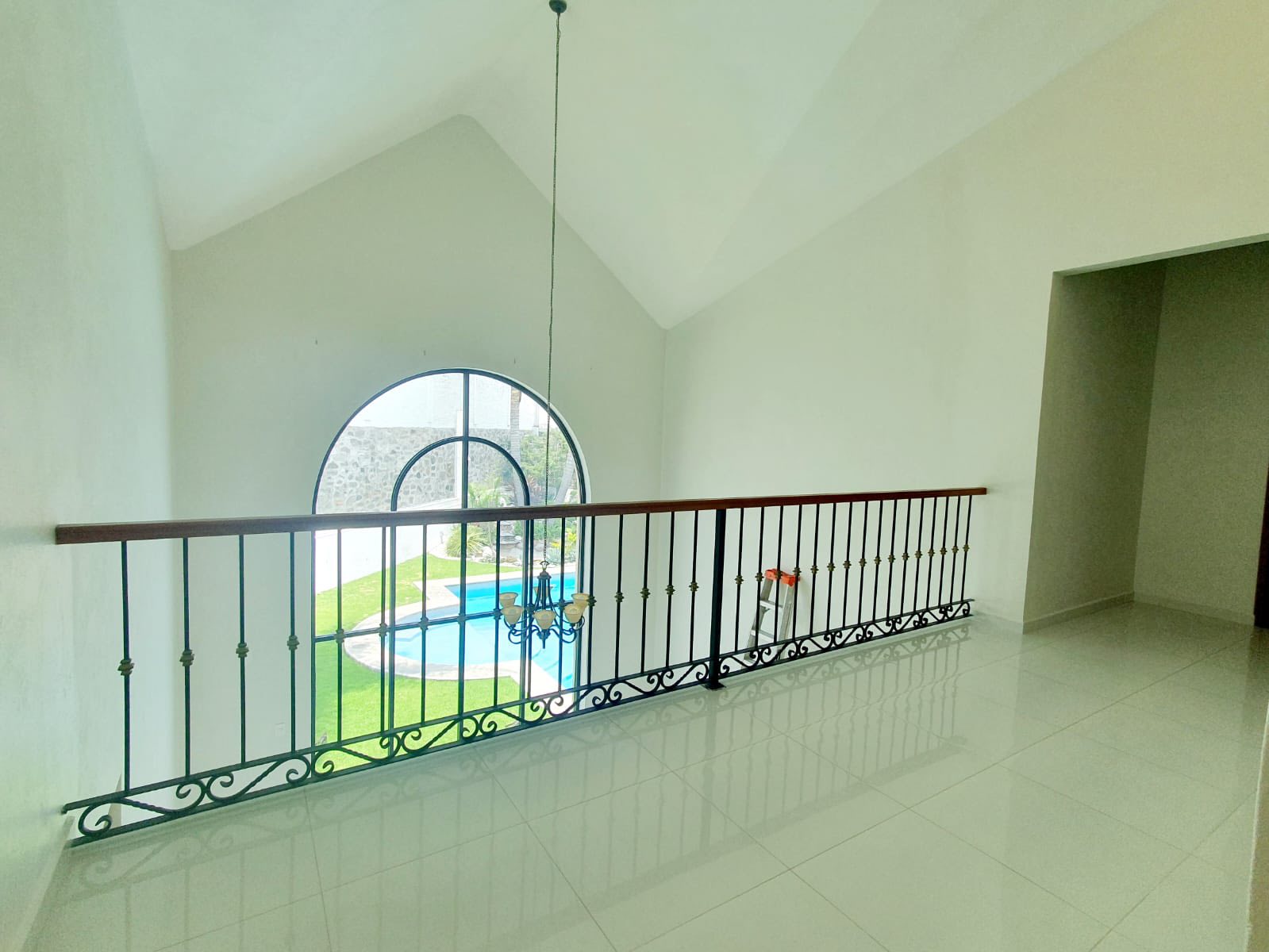 Sala con vista a la alberca y ventanales que permiten entrada de luz natural.