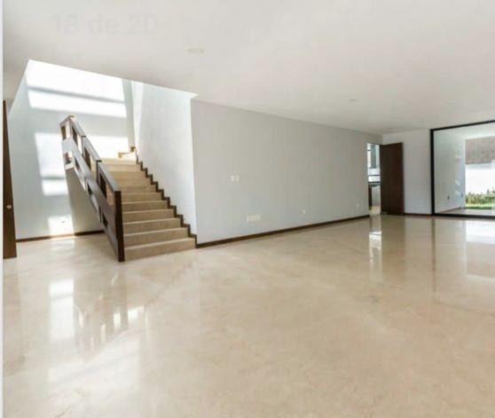 Sala amplia y luminosa con escaleras de acceso a los niveles superiores.