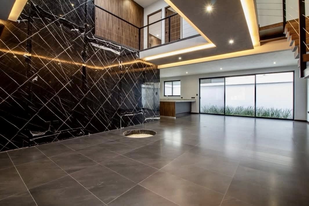 Espacio de sala con iluminación LED y ventanales de piso a techo.