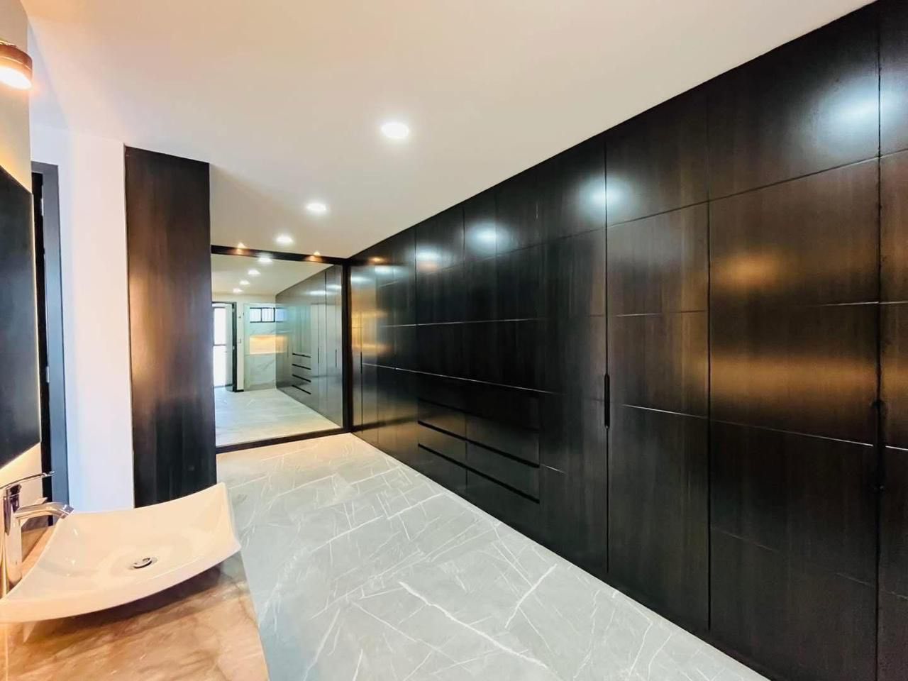 Recámara principal con vestidor amplio y baño en suite con acabados modernos.