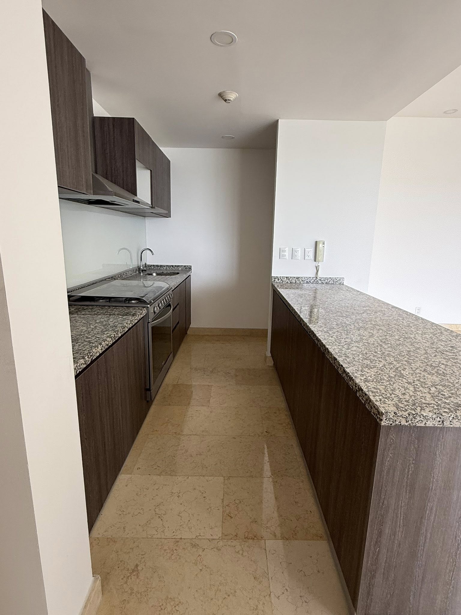 Cocina con barra de granito y gabinetes de madera.