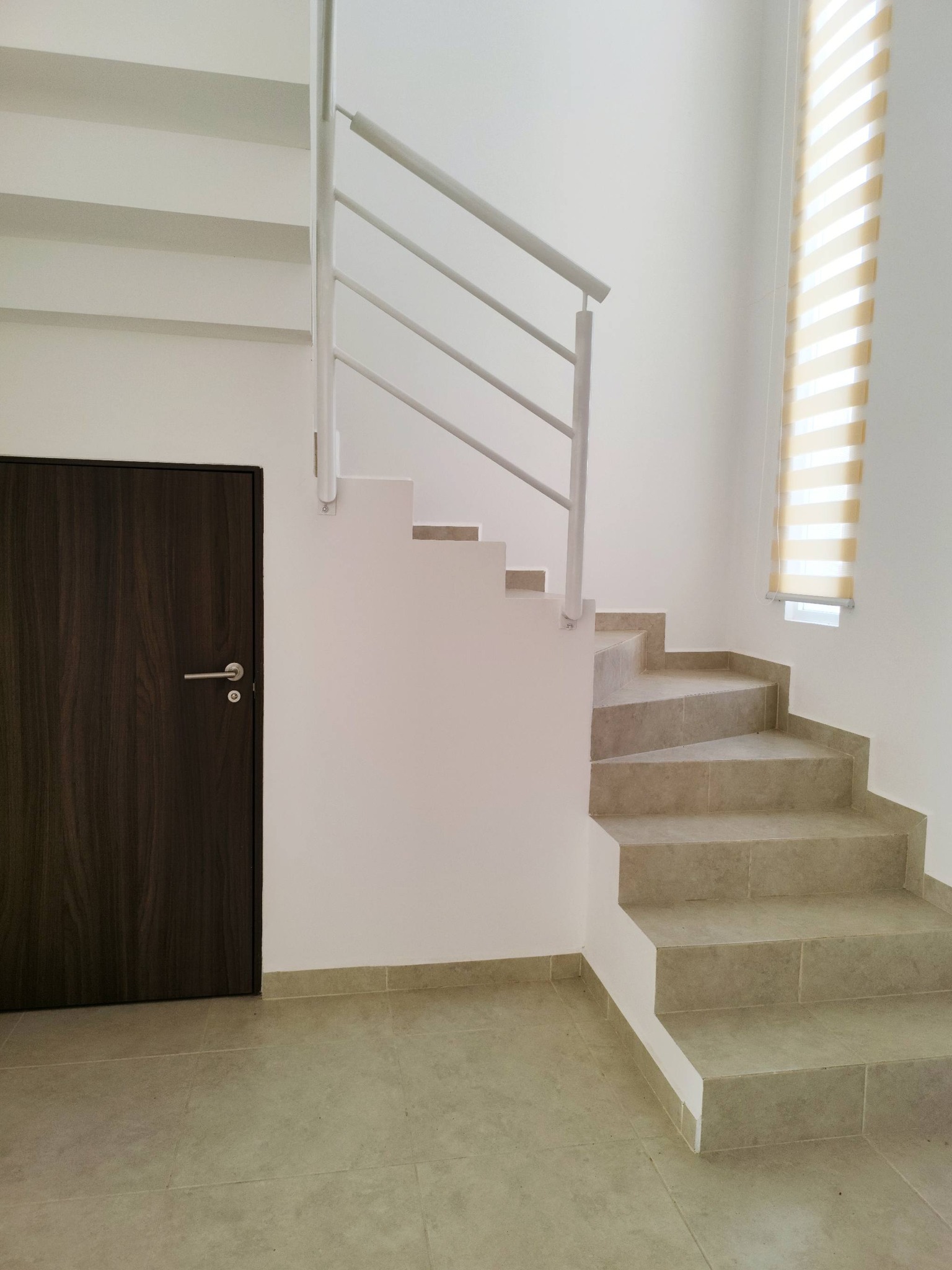 Escaleras minimalistas con barandal blanco.