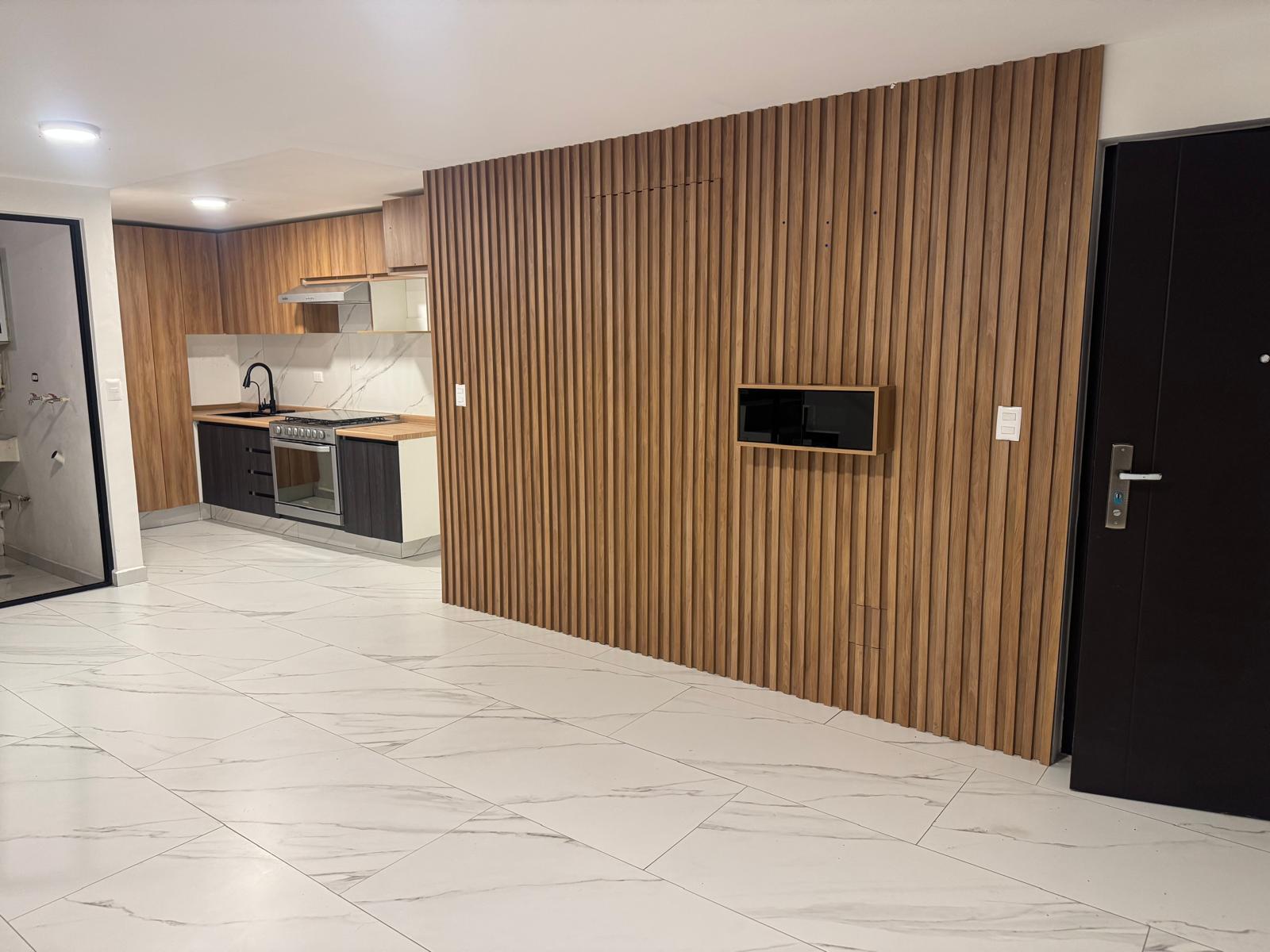 Cocina integral con acabados en madera y electrodomésticos modernos.
