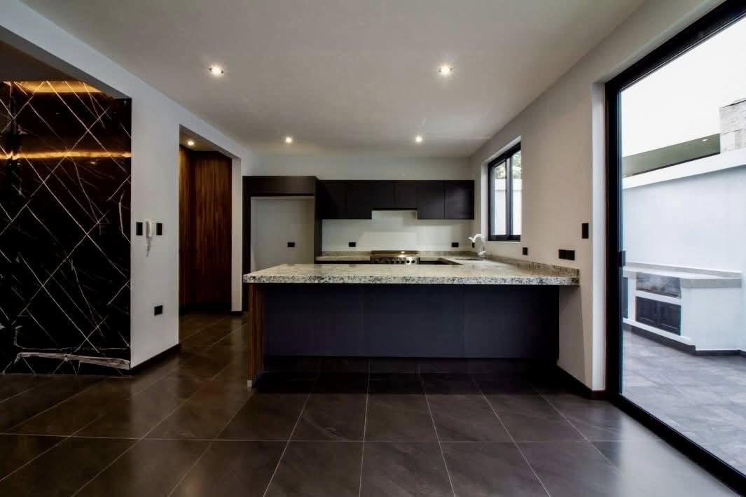 Cocina integral con isla de granito y gabinetes modernos.