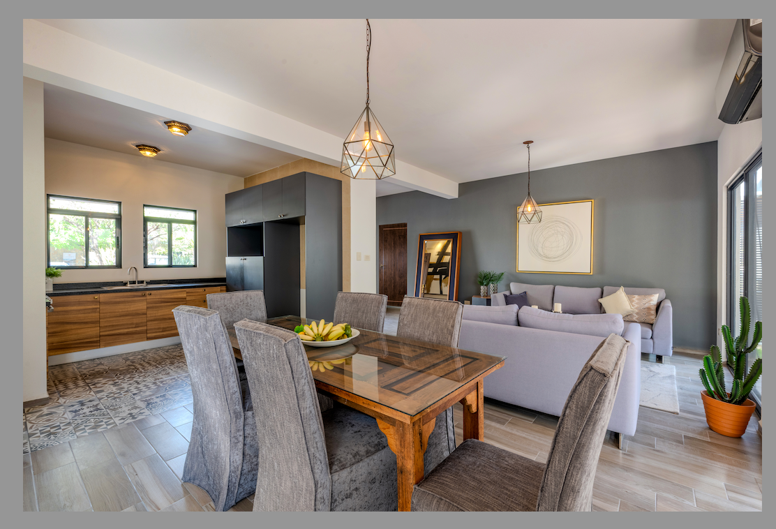 Espacio abierto que integra sala, comedor y cocina con decoración moderna.